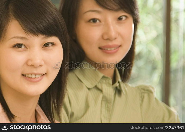 Portrait of two female office workers smiling in an office