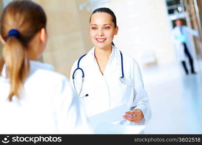 Portrait of two friendly female doctors in hospital discussing something