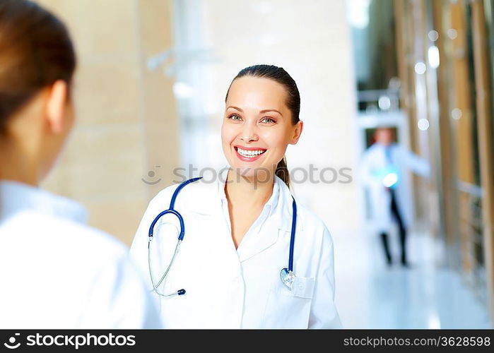 Portrait of two friendly female doctors in hospital discussing something