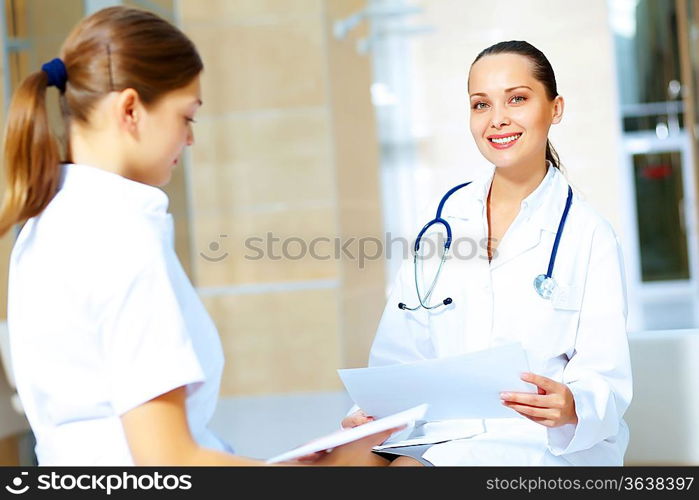 Portrait of two friendly female doctors in hospital discussing something