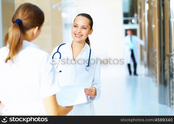 Portrait of two friendly female doctors. Portrait of two friendly female doctors in hospital discussing something