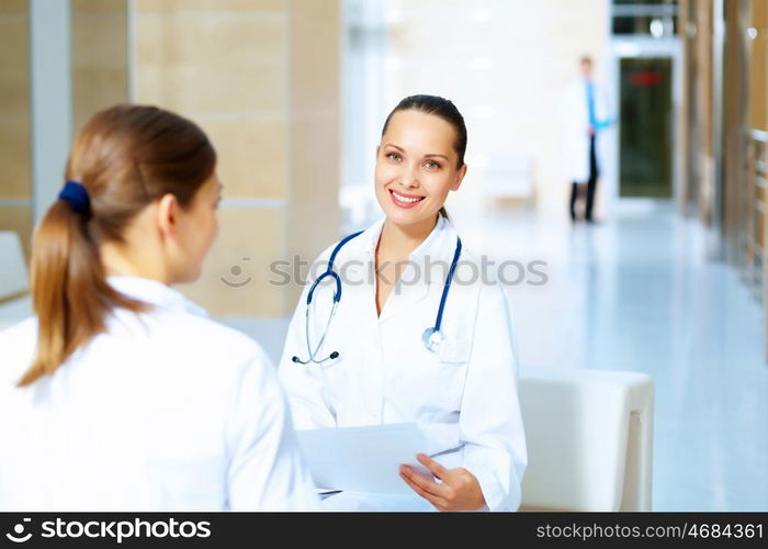 Portrait of two friendly female doctors. Portrait of two friendly female doctors in hospital discussing something