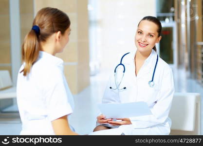 Portrait of two friendly female doctors. Portrait of two friendly female doctors in hospital discussing something