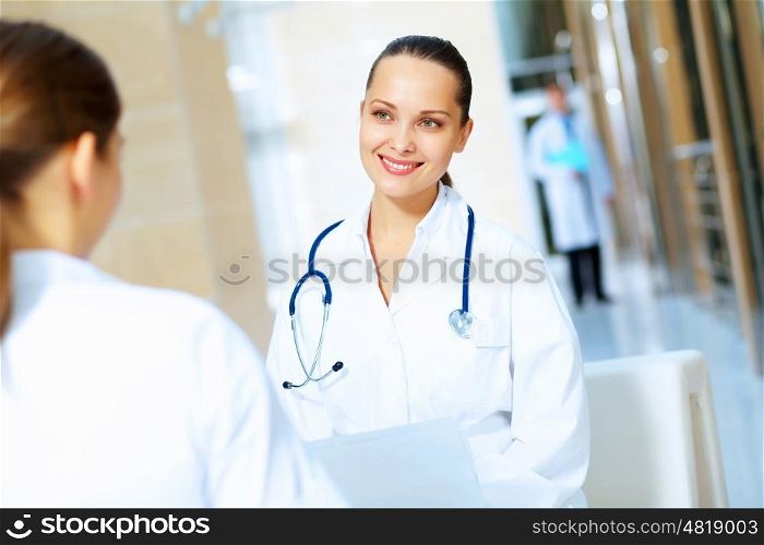 Portrait of two friendly female doctors. Portrait of two friendly female doctors in hospital discussing something