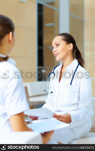 Portrait of two friendly female doctors. Portrait of two friendly female doctors in hospital discussing something