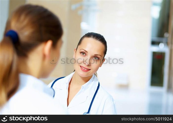 Portrait of two friendly female doctors. Portrait of two friendly female doctors in hospital discussing something