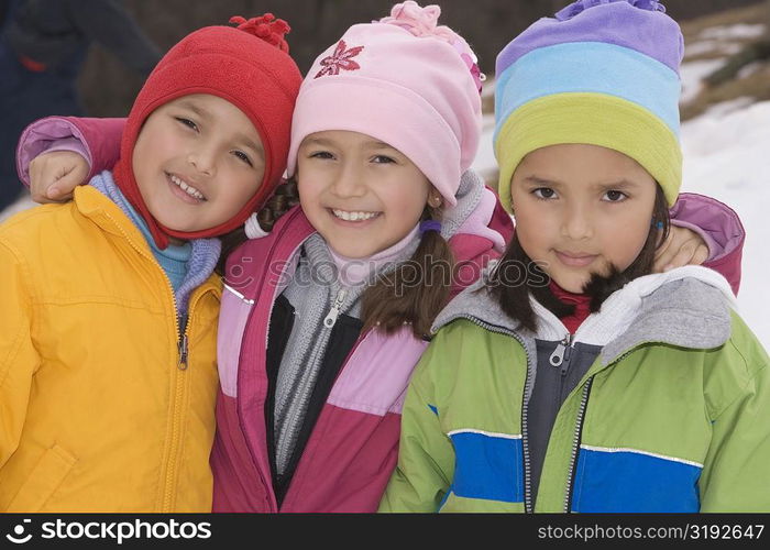 Portrait of two girls and a boy standing together and smiling