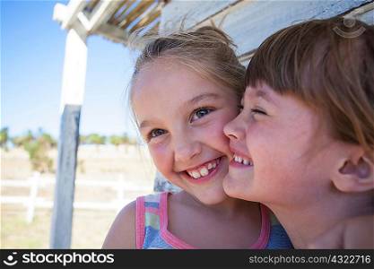 Portrait of two girls cheek to cheek smiling