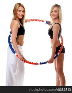 portrait of two girls exercising with hula hoops in gym. Fitness woman isolated on white