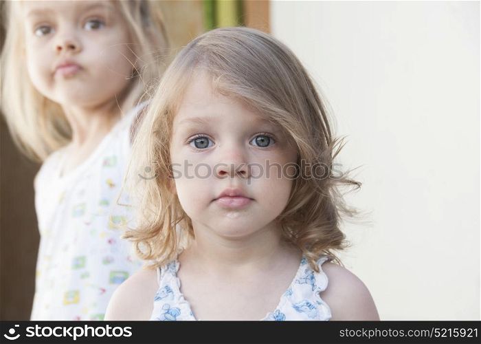 Portrait of two girls: four-year-old girl in the background, two-year at the front
