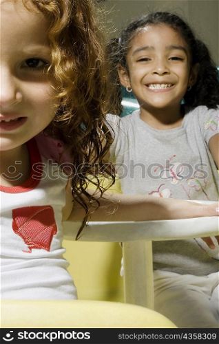 Portrait of two girls in a toy car