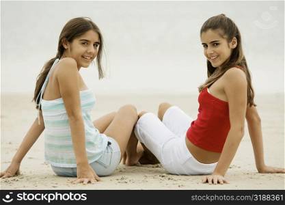 Portrait of two girls sitting on the beach
