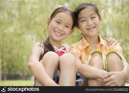 Portrait of two girls sitting together and smiling