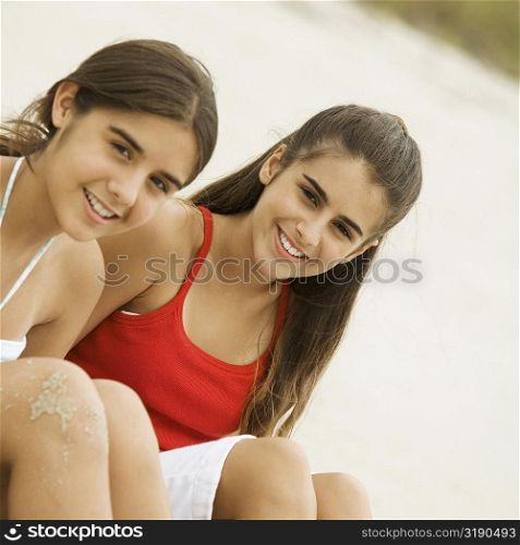 Portrait of two girls sitting together smiling