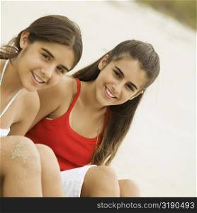 Portrait of two girls sitting together smiling
