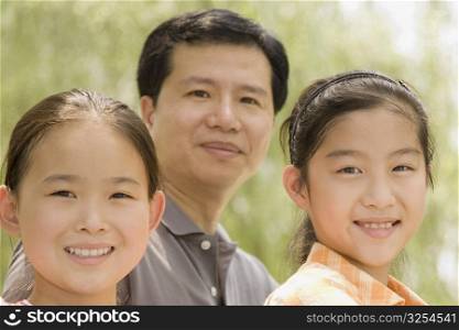 Portrait of two girls smiling with their father