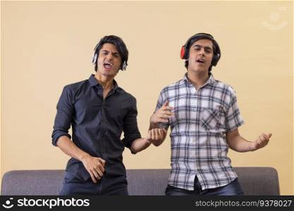Portrait of two happy teenage boys listening to music and gesturing