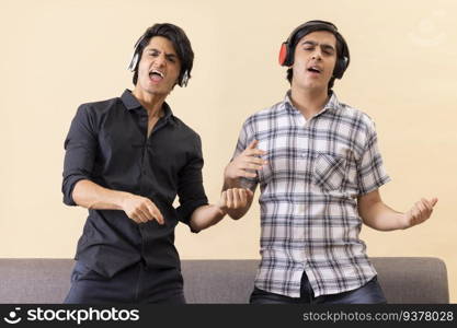 Portrait of two happy teenage boys listening to music and gesturing