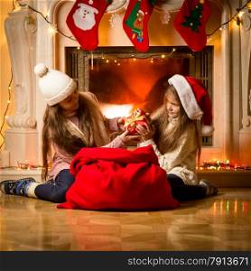 Portrait of two little girls having a fight of present on Christmas
