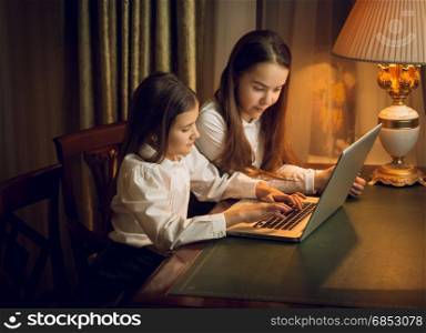 Portrait of two little sisters using laptop