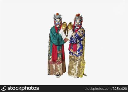 Portrait of two male Chinese opera performers holding bowls full of gold coins
