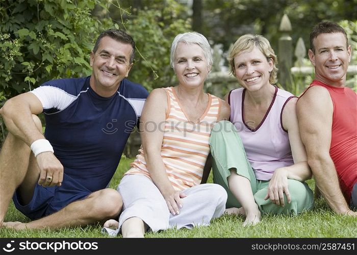 Portrait of two mature couples sitting in a park
