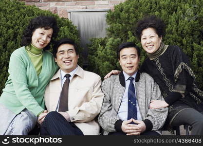 Portrait of two mature couples sitting together smiling