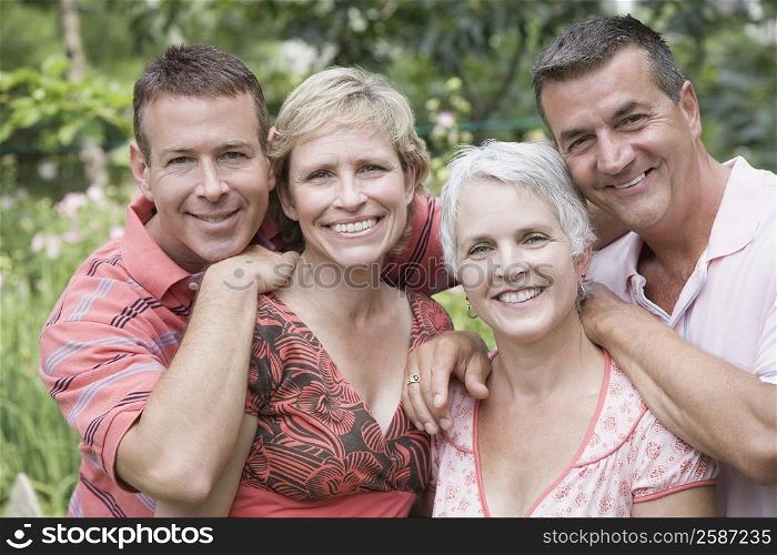 Portrait of two mature couples smiling in a park