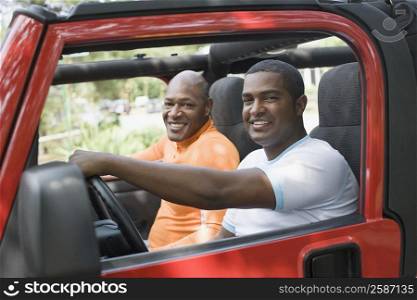 Portrait of two mature men smiling in a jeep