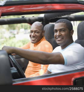 Portrait of two mature men smiling in a jeep