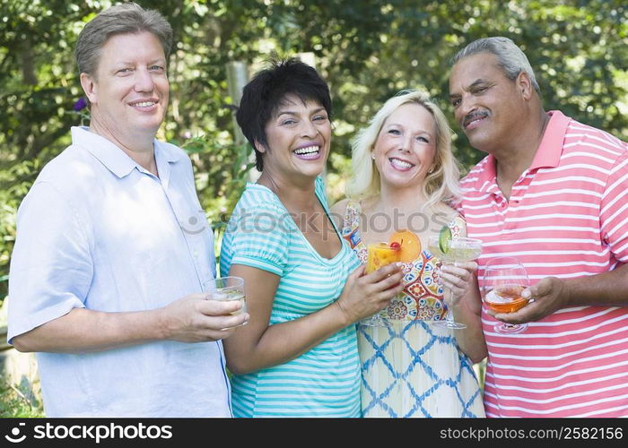 Portrait of two mature women holding glasses of martini and a mature man with a senior man holding glasses of wine