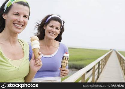 Portrait of two mature women holding ice cream cones and smiling