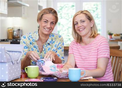 Portrait Of Two Mature Women Sewing Quilt Together