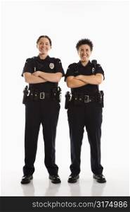 Portrait of two mid adult Caucasian policewomen standing with arms crossed looking at viewer smiling.