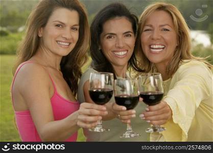 Portrait of two mid adult women and a mature woman holding wine glasses