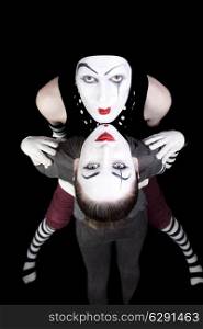 Portrait of two mimes on black background