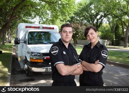 Portrait of two paramedics standing in front of ambulance vehicle