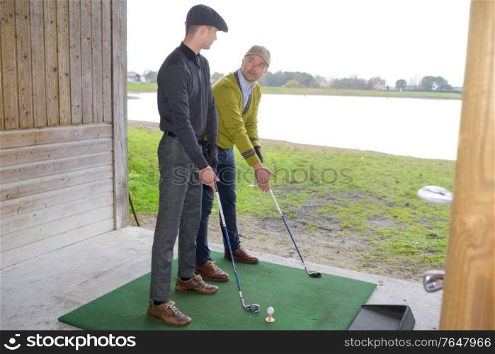 portrait of two people doing golf