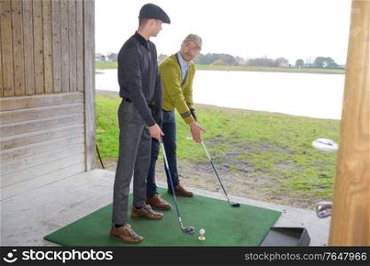 portrait of two people doing golf