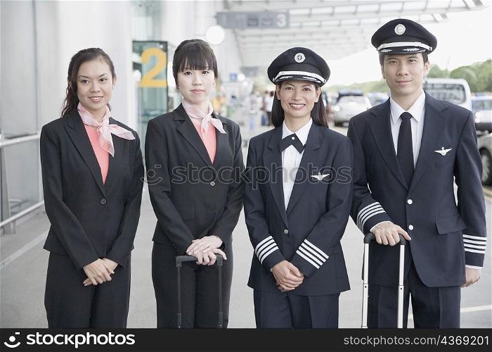 Portrait of two pilots standing with two cabin crews