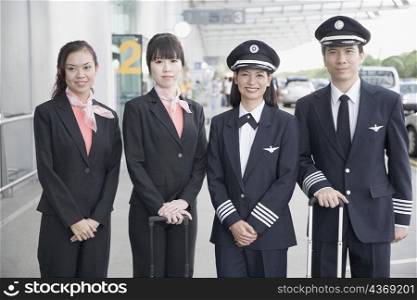 Portrait of two pilots standing with two cabin crews