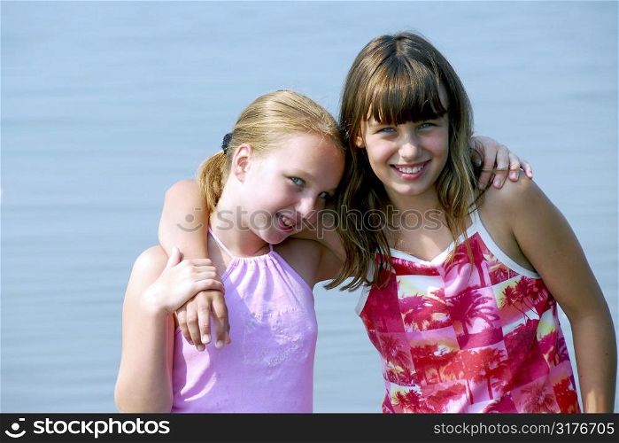 Portrait of two preteen girls standing in water
