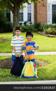Portrait of two schoolboys holding schoolbags
