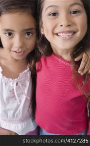 Portrait of two schoolgirls smiling together