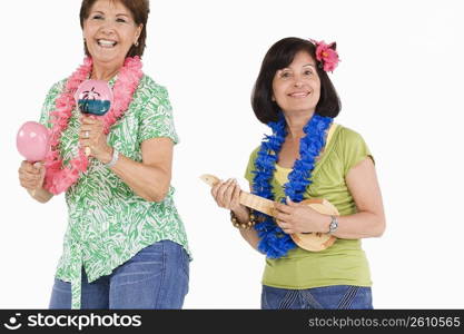 Portrait of two senior women playing ukulele and maracas