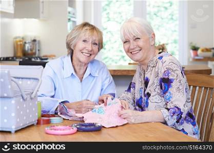 Portrait Of Two Senior Women Sewing Quilt Together