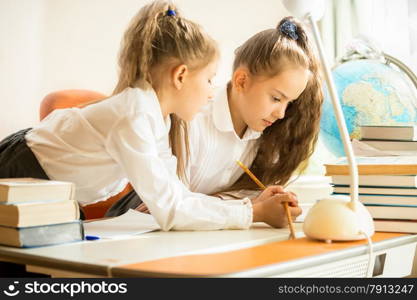 Portrait of two sisters in uniform doing homework