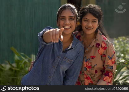 Portrait of two smiling women pointing