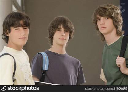 Portrait of two teenage boys standing with a young man