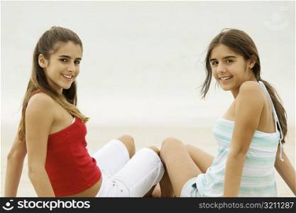 Portrait of two teenage girls smiling on the beach